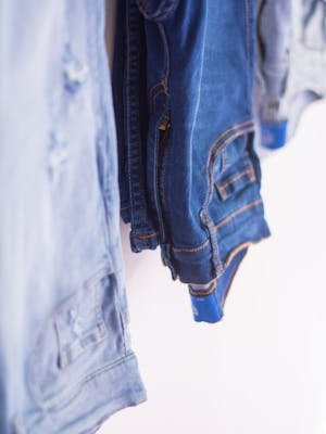 Artistic close-up of various shades of denim jeans, emphasizing texture and fashion style.